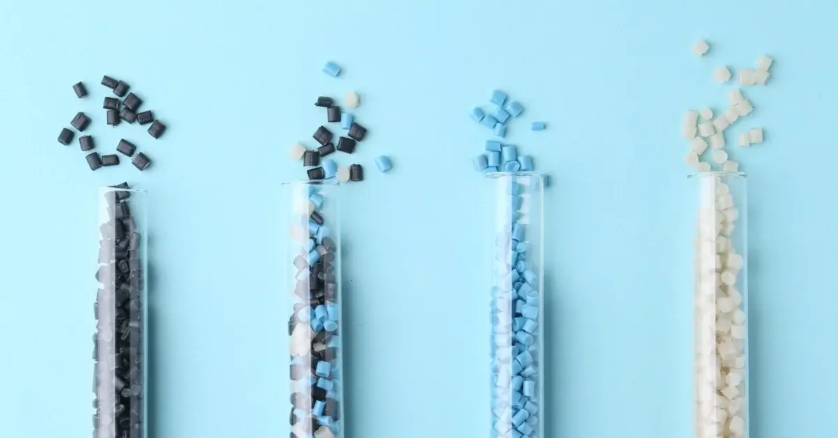 granulos de polímeros plástico coloridos com fundo azul